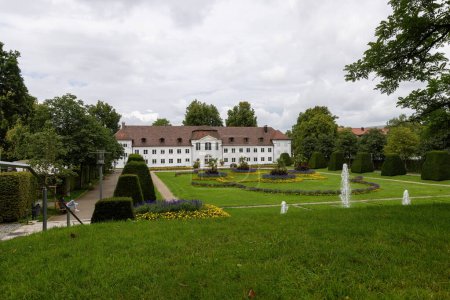 Téléchargez les photos : Kempten, Allemagne 05 août 2023 : Vue de la bibliothèque de la ville de Kempten à travers le Hofgarten par une journée d'été nuageuse - en image libre de droit