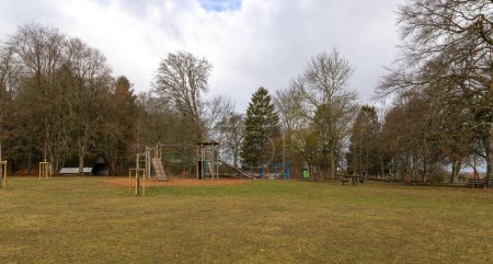 Spielplatz mit verschiedenen Holzgeräten im Wald