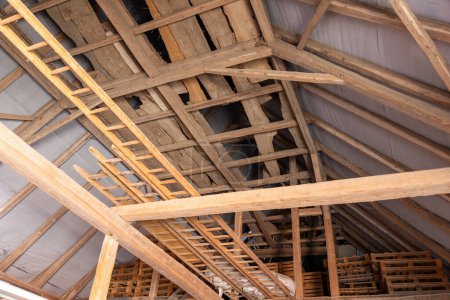 Attic of a barn with waterproofing and various pallets and wooden boxes