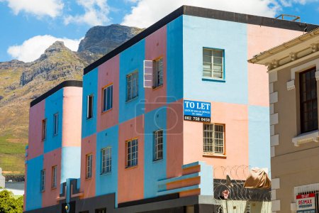 Foto de Ciudad del Cabo, Sudáfrica - 7 de diciembre de 2022: Colorido bloque antiguo de pisos en la ciudad con la montaña en el fondo - Imagen libre de derechos