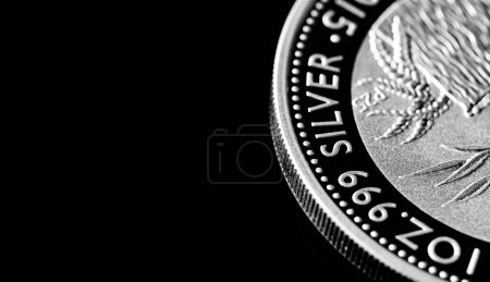 Macro Primer plano de Moneda de lingotes de plata sobre un fondo de espejo negro