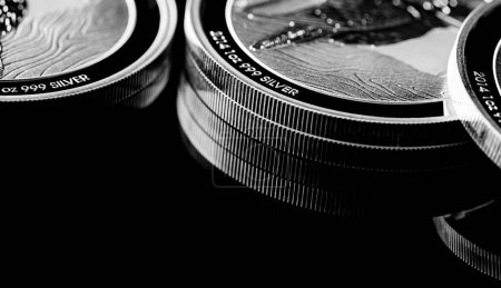 Macro Primer plano de Moneda de lingotes de plata sobre un fondo de espejo negro