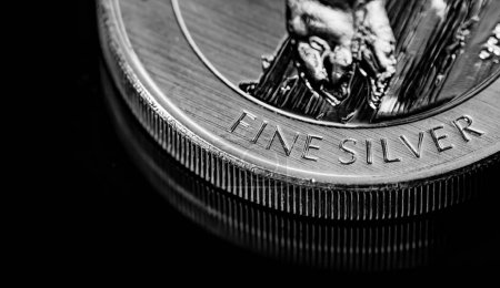 Makro-Nahaufnahme der Silbermünze auf schwarzem Spiegelhintergrund