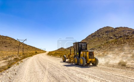 Photo for Richtersveld, South Africa - March 11, 2024: Large Caterpillar gravel dirt road grader smoothing out a road surface - Royalty Free Image