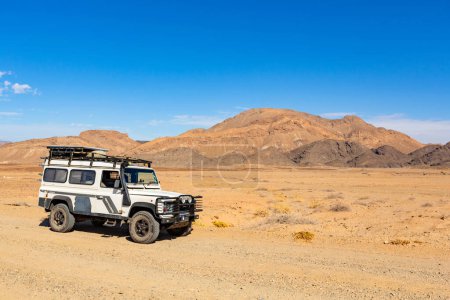 Photo for Richtersveld, South Africa - March 12, 2024: Old Land Rover Defender parked on a gravel road in arid region - Royalty Free Image