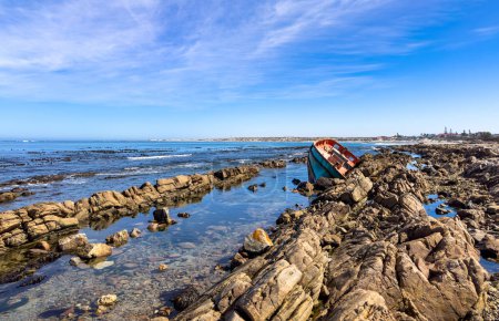 Shipwrecked diamond mining vessel on rocky shoreline in small West Coast town of Port Nolloth, South Africa