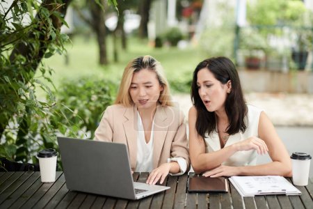 Photo for Female entrepreneurs discussing documents on laptop screen - Royalty Free Image