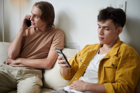 Téléchargez les photos : Friends spending time talking on phone and texting instead of talking to each other - en image libre de droit
