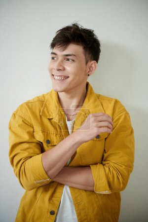 Téléchargez les photos : Portrait of happy young man in yellow demin jacket looking away - en image libre de droit