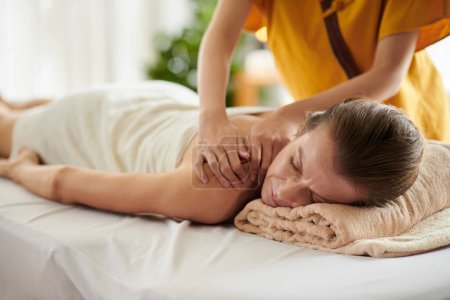Téléchargez les photos : Middle-aged woman getting massage with oils in beauty salon - en image libre de droit