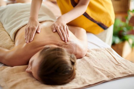 Téléchargez les photos : Hands of masseuse spreading oil on back of client - en image libre de droit