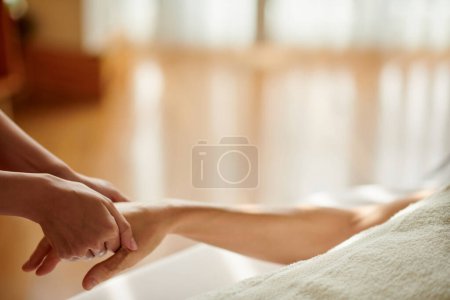 Photo for Masseuse massaging hand of female client to release stress and anxiety - Royalty Free Image