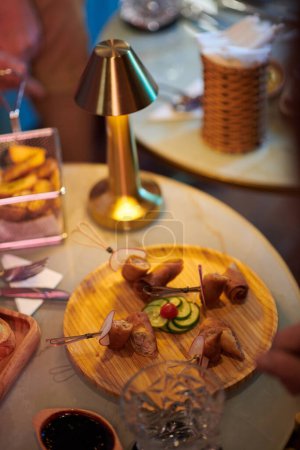Téléchargez les photos : Wooden round plate with delicious snacks on cafe table - en image libre de droit