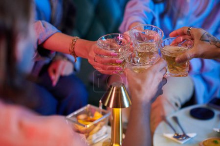 Téléchargez les photos : Group of young people clinking glasses with booze at party - en image libre de droit