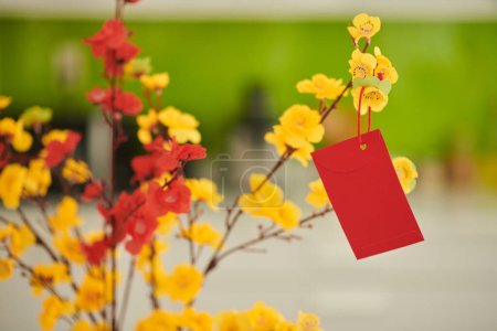Téléchargez les photos : Small red lucky money envelope hanging on blooming apricot branches - en image libre de droit