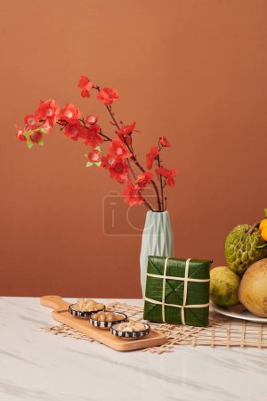 Téléchargez les photos : Fermented vegetables, sticky rice cake and vase with peach branches on table - en image libre de droit