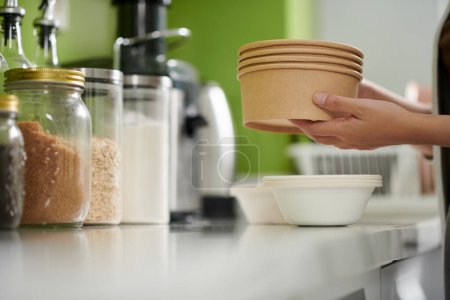 Foto de Woman taking out disposable bowls for breakfast oatmeal - Imagen libre de derechos