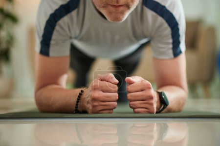 Téléchargez les photos : Cropped image of fit man doing plank exercise as part of core muscle strength and stability test - en image libre de droit