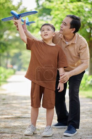 Photo for Grandfather playing with grandson with handmade airplane - Royalty Free Image