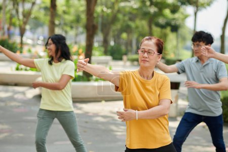 Téléchargez les photos : Senior woman exercising outdoors with her family - en image libre de droit