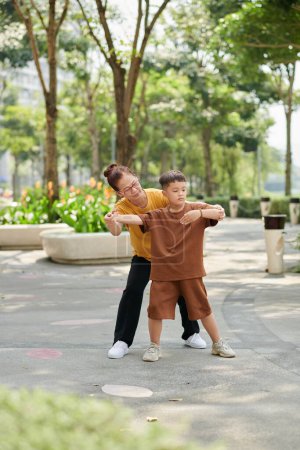 Téléchargez les photos : Little boy exercising in park with his grandmother - en image libre de droit