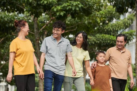 Photo for Joyful Vietnamese family walking in city park, spending weekend together - Royalty Free Image