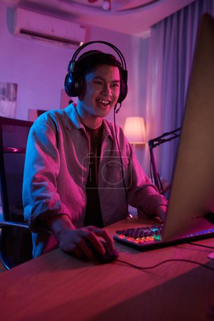 Foto de Excited teenage boy playing videogame at night - Imagen libre de derechos