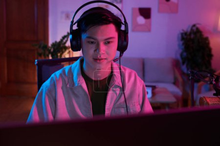 Téléchargez les photos : Teenage boy playing online videogame with friends at night - en image libre de droit