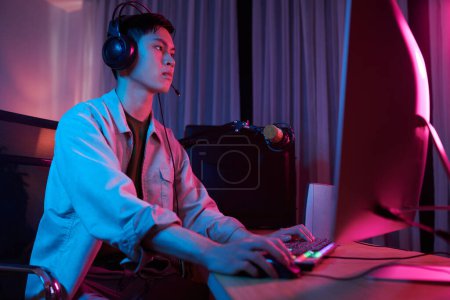 Téléchargez les photos : Streamer recording himself playing videogame late at night - en image libre de droit