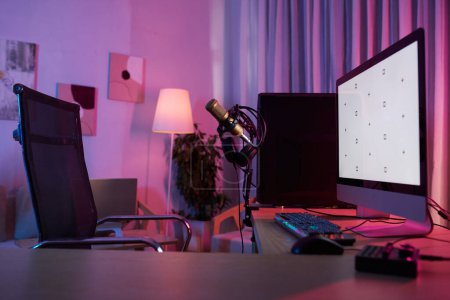 Téléchargez les photos : Professional microphone, computer monitor and keyboard on desk of gamer - en image libre de droit
