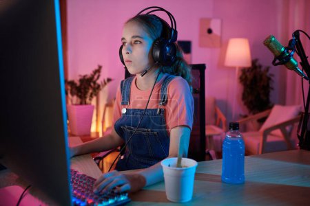 Photo for Teenage girl having ice-cream and sweet drink when playing on computer at night - Royalty Free Image