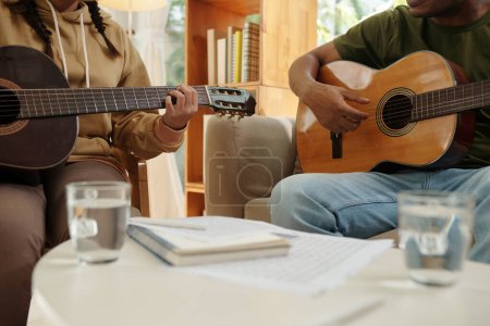 Téléchargez les photos : Teacher and student playing guitar together at home - en image libre de droit