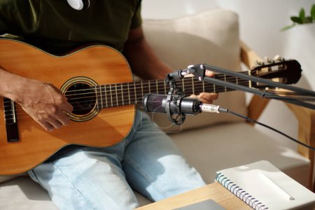 Photo for Musician set miscrophone to record sound of his acoustic guitar - Royalty Free Image