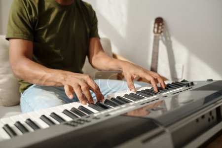 Photo for Hands of talented man playing synthesizer when working on new song - Royalty Free Image