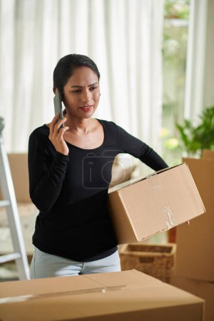 Téléchargez les photos : Woman calling to moving company asking why movers are late - en image libre de droit