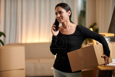 Téléchargez les photos : House owner packing her belongigns and calling to moving service - en image libre de droit