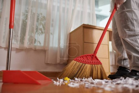Téléchargez les photos : Image rapprochée du travailleur essuyant le sol sale dans la maison du client - en image libre de droit