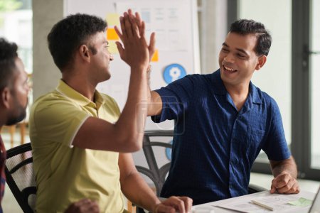 Téléchargez les photos : Joyful developers giving each other high five after having succeful meeting with investors - en image libre de droit