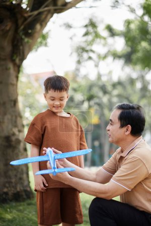 Photo for Grandfather explaining preteen grandson how plane works - Royalty Free Image