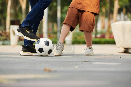 Photo for Closeup image of father playing football with preteen son - Royalty Free Image