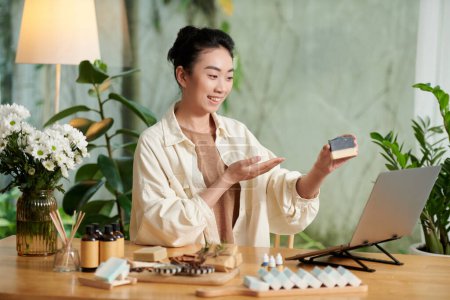 Téléchargez les photos : Joyful woman streaming class on making soap bars with essential oils at home - en image libre de droit