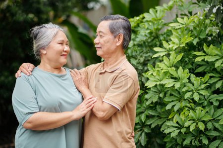 Photo for Happy senior couple in love standing outdoors and looking at each other - Royalty Free Image