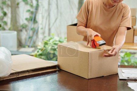 Téléchargez les photos : Commandes d'emballage femme et boîtes de carton d'étanchéité pour la livraison aux clients - en image libre de droit