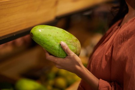 Photo for Closeup image of woman buying green mangoes in in grocery store - Royalty Free Image