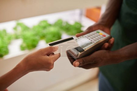 Téléchargez les photos : Image rapprochée de la femme qui paie ses courses avec sa carte de crédit - en image libre de droit