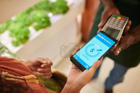 Photo for Closeup image of customer paying for purchases with mobile application - Royalty Free Image