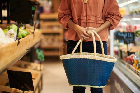 Foto de Cropped image of woman with big bag shopping in grocery store - Imagen libre de derechos