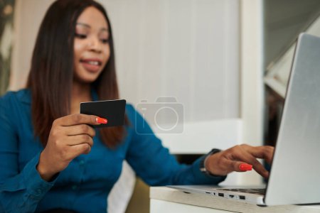 Photo for Happy woman using credit card to pay for her online purchases - Royalty Free Image