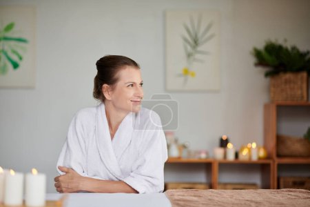 Téléchargez les photos : Smiling woman in soft bath towel enjoying spending weekend in spa salon - en image libre de droit