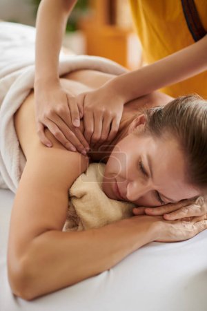 Téléchargez les photos : Mature woman getting relaxing shoulder massage in spa salon - en image libre de droit